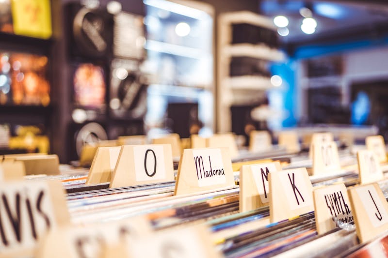 Vinilos de música ordenados alfabéticamente con etiquetas en una tienda de discos
