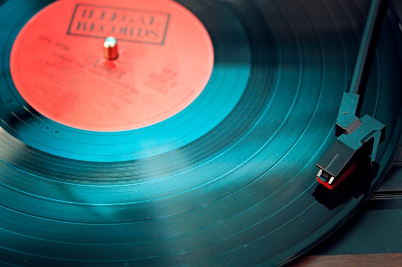 Disco de vinilo girando en un tocadiscos con la aguja apoyada sobre los surcos