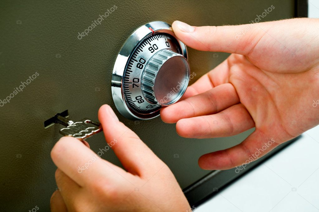 Manos girando el dial de combinación de una caja fuerte personal para abrirla