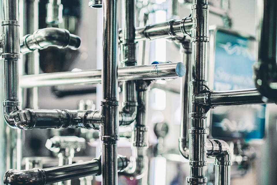 Tuberías industriales conectadas en serie representando un pipeline de procesamiento de datos con flujo controlado