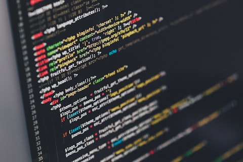 Monitor mostrando líneas de código con un café al lado