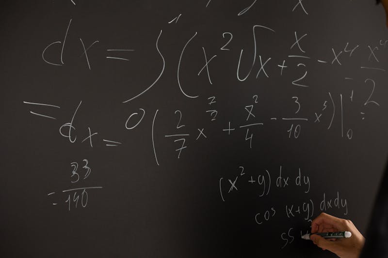 Papel con anotaciones numéricas y una calculadora científica sobre una mesa